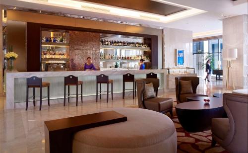 a bar in a hotel lobby with people in the background at Radisson Blu Hotel Liuzhou in Liuzhou