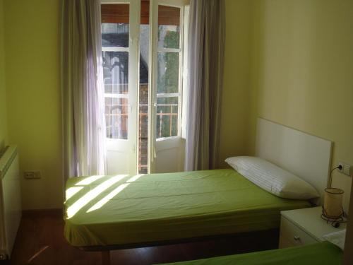Un dormitorio con una cama frente a una ventana. en Apartamentos Valles, en Broto