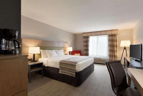 a hotel room with a bed and a television at Country Inn & Suites by Radisson, Minneapolis-Shakopee in Shakopee