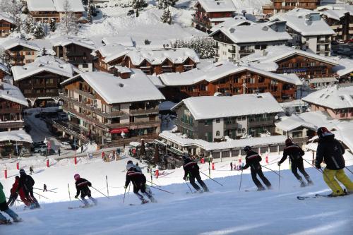 a group of people skiing down a snow covered slope at Bellevue in Les Gets