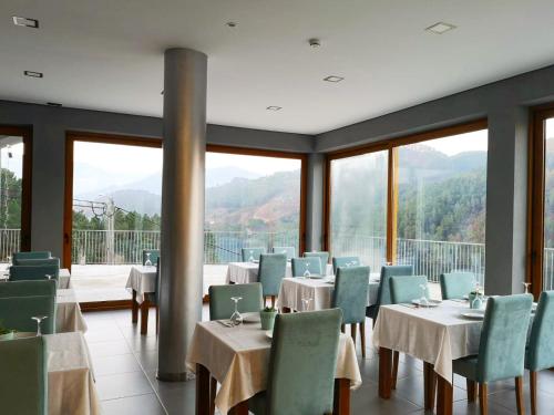 a restaurant with tables and chairs with mountains in the background at Solar do Cávado in Vieira do Minho