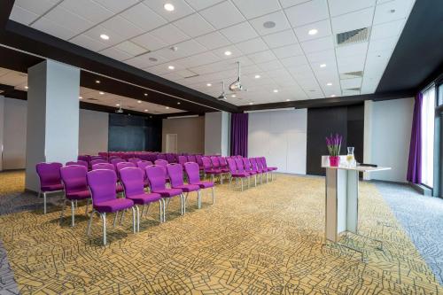 une salle de conférence avec des chaises violettes et une table dans l'établissement Park Inn by Radisson Lille Grand Stade, à Villeneuve d'Ascq