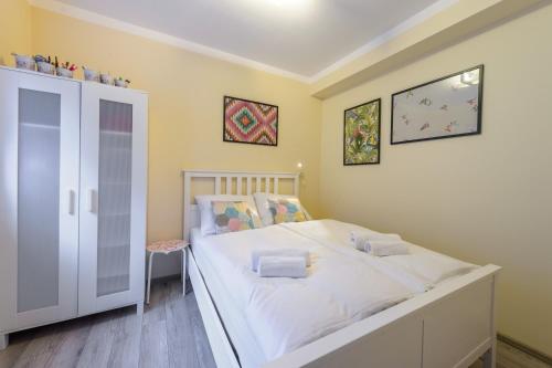 a bedroom with a large bed with white sheets at Apartament Kawowy - 5D Apartamenty in Świeradów-Zdrój
