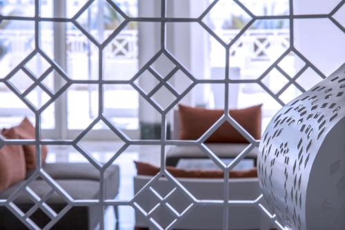 a room with a glass partition with a chair and a window at Radisson Blu Resort & Thalasso Hammamet in Hammamet