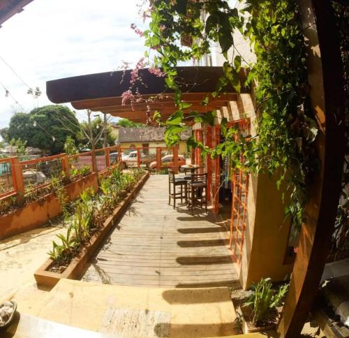 a wooden walkway with a table and chairs on a building at Maloca Hospedagem in Sao Jorge