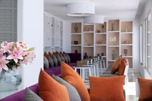 a room with couches and a table with chairs at Radisson Blu Resort & Thalasso Hammamet in Hammamet