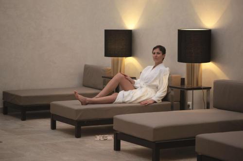 a woman sitting on a couch in a room at Radisson Blu Resort & Thalasso Hammamet in Hammamet