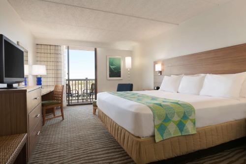 una camera d'albergo con un grande letto e una TV di DoubleTree by Hilton Corpus Christi Beachfront a Corpus Christi
