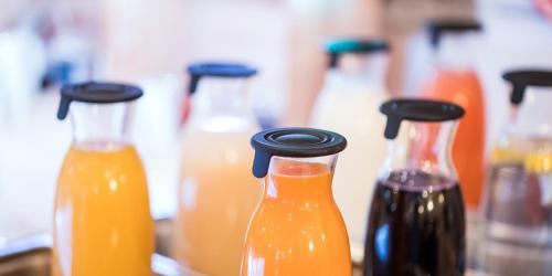 a group of bottles of orange juice on a counter at Hotel Hangelar in Sankt Augustin