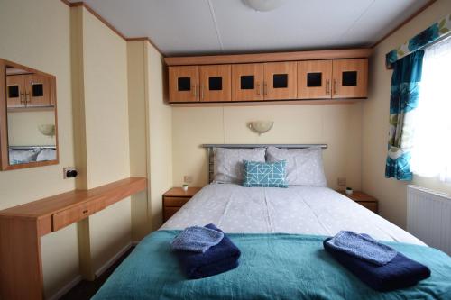 um quarto com uma cama com almofadas azuis em Locatie Het Knooppunt Engelse Chalet em Nuis