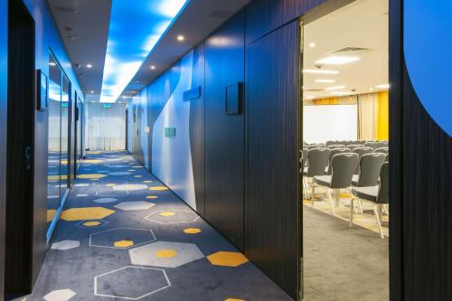 an office corridor with a conference room with chairs at Park Inn by Radisson Hotel Astana in Astana