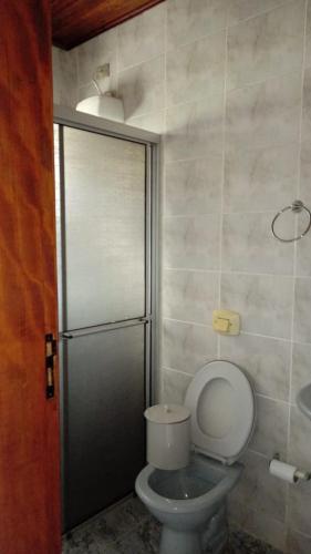 a bathroom with a toilet and a shower stall at Casa Guaratuba espaçosa e confortável in Guaratuba