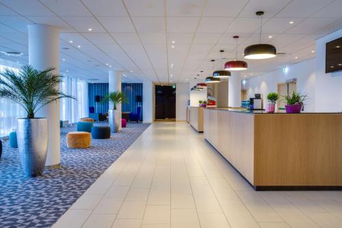 an office lobby with a reception desk and potted plants at Radisson Blu Hotel Oslo Alna in Oslo