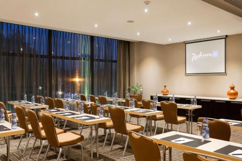 a conference room with tables and chairs and a projection screen at Radisson Blu Hotel, Addis Ababa in Addis Ababa