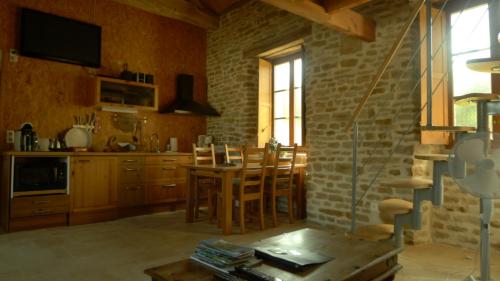 eine Küche mit einem Tisch und Stühlen im Zimmer in der Unterkunft gîte de la Cabotte in Bussy-le-Grand