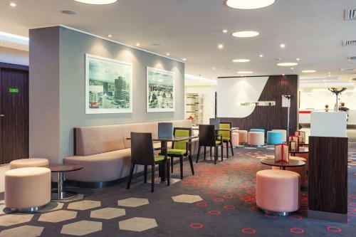 a lobby with tables and chairs in a building at Park Inn by Radisson Hotel Astana in Astana