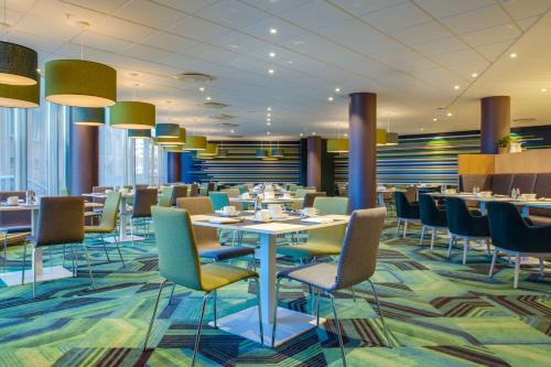 a dining room with tables and chairs and lights at Radisson Blu Hotel Oslo Alna in Oslo
