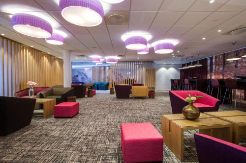 una sala de espera con sillas, mesas y luces púrpuras en Radisson Blu Hotel Oslo Alna en Oslo