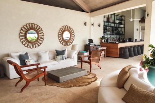 a living room with a couch and chairs and a table at The Liming Bequia in Friendship