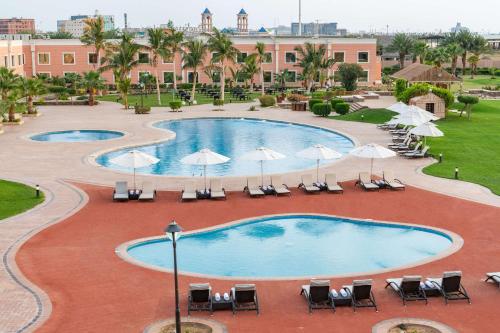 a pool at the resort with chairs and umbrellas at Radisson Blu Resort Jizan in Jazan