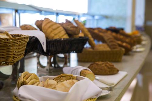a long table with baskets of bread and pastries at Radisson Blu Resort Jizan in Jazan