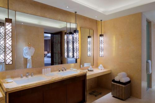 a bathroom with a sink and a large mirror at Radisson Blu Hotel Kashgar in Kashgar