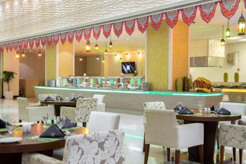 a restaurant with tables and chairs and a bar at Radisson Blu Resort Jizan in Jazan