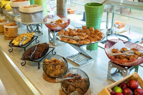 a buffet with many baskets of bread and other food at Radisson Blu Resort Jizan in Jazan
