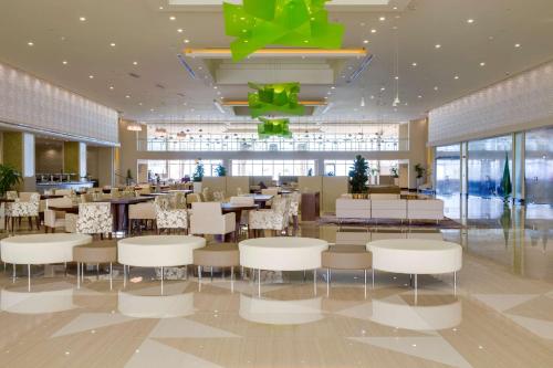 a restaurant with white chairs and tables in a building at Radisson Blu Resort Jizan in Jazan