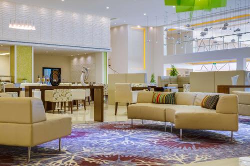 a lobby with couches and tables and a dining room at Radisson Blu Resort Jizan in Jazan