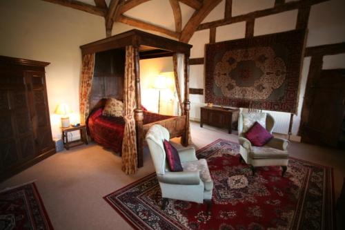 a bedroom with a bed and two chairs and a rug at Blackmore Farm in Bridgwater