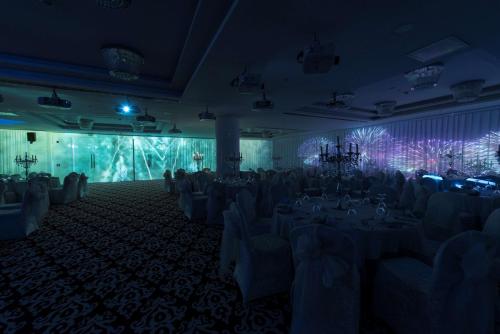 a banquet hall with tables and chairs in a room with purple lighting at Park Inn by Radisson Ankara Cankaya in Ankara