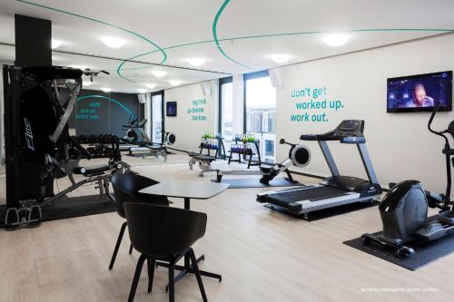 a gym with exercise equipment and a sign on the wall at Radisson Blu Hotel, Mannheim in Mannheim