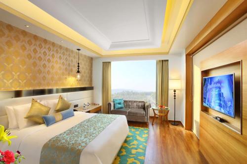 a hotel room with a bed and a tv at Radisson Blu Jammu in Jammu