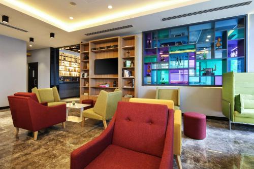 una sala de espera con sillas coloridas y TV en Park Inn by Radisson Izmir en İzmir