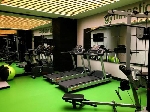 a gym with several tread machines on a green floor at Park Inn by Radisson Izmir in İzmir