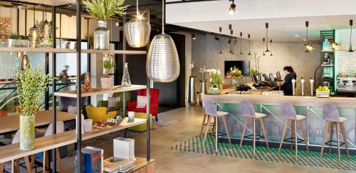 a restaurant with a bar with purple stools at Park Inn By Radisson Hasselt in Hasselt