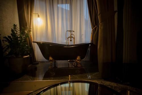 a bath tub in a bathroom with a window at Noble Boutique Hotel - Adults Only in Budapest