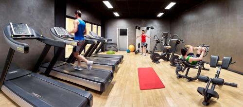 a gym with people exercising on tread machines in a gym at Park Inn By Radisson Hasselt in Hasselt
