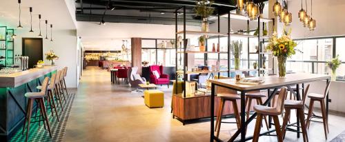 a restaurant with a bar with chairs and tables at Park Inn By Radisson Hasselt in Hasselt