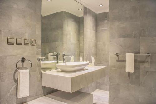 a bathroom with a sink and a bath tub at Radisson Blu Resort, Al Khobar Half Moon Bay in Half Moon Bay