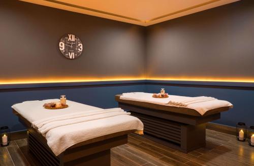 two beds in a room with a clock on the wall at Park Inn by Radisson Istanbul Atasehir in Istanbul