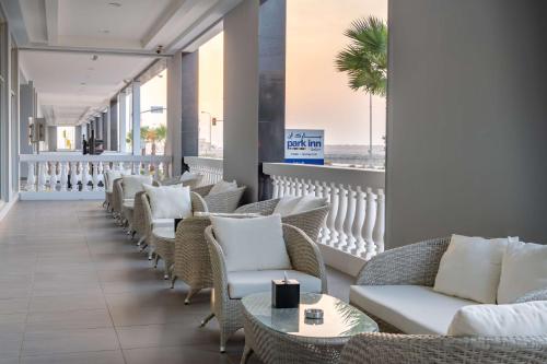 a lounge with chairs and tables and a view of the beach at Park Inn by Radisson Jubail Industrial City in Al Jubail