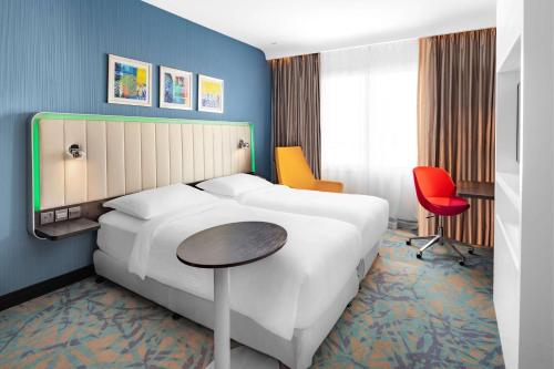 a hotel room with a large white bed and a table at Park Inn by Radisson Jubail Industrial City in Al Jubail