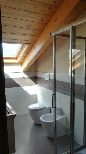 a bathroom with a toilet and a glass shower at Casa da Brunetto in Costarainera