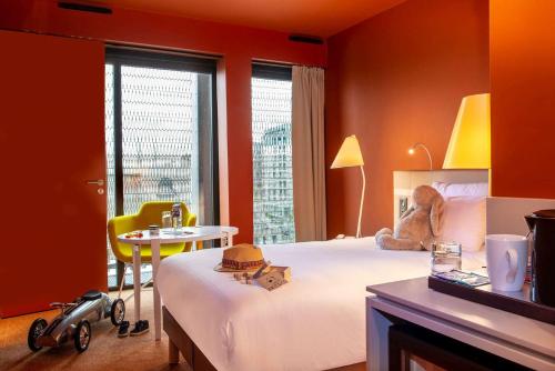 a bedroom with a bed and a table and a chair at Radisson Blu Hotel Bordeaux in Bordeaux