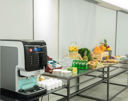 a coffee machine sitting on a table with food at Park Inn by Radisson Jubail Industrial City in Al Jubail