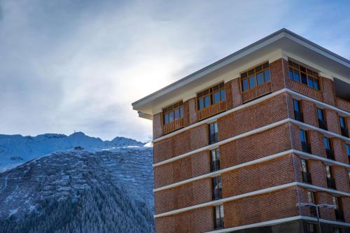 - un bâtiment avec vue sur la montagne dans l'établissement Radisson Blu Hotel Reussen, Andermatt, à Andermatt