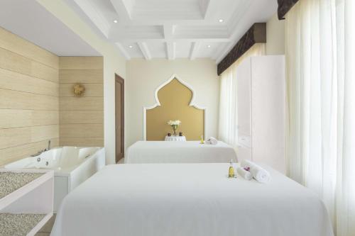a white bedroom with a bed and a tub and a sink at Radisson Chandigarh Zirakpur in Chandīgarh