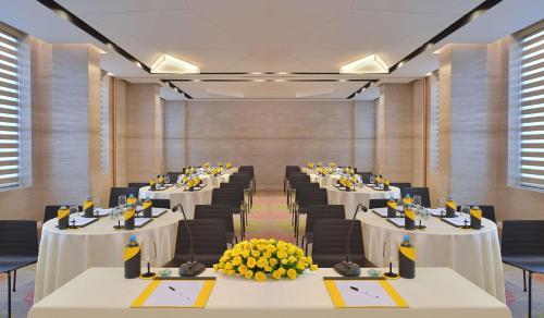 a conference room with white tables and black chairs at Radisson Bengaluru City Center in Bengaluru